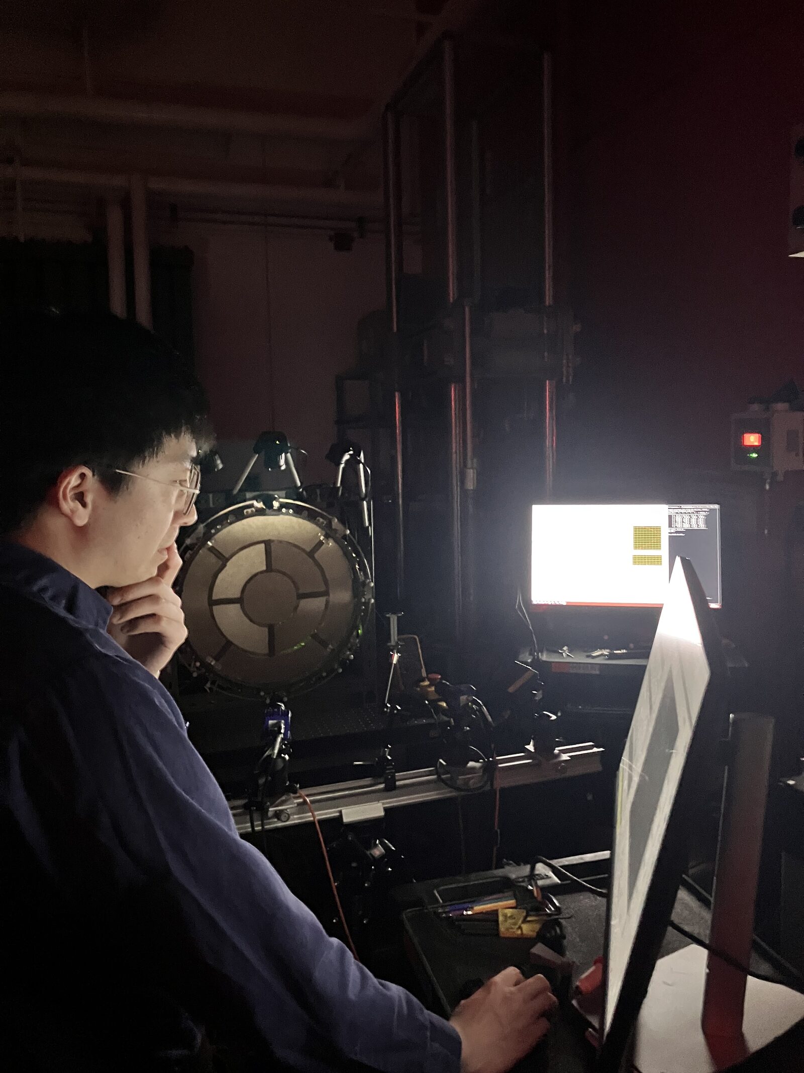 Mithril engineer inspecting an actuated mesh reflector prototype in the lab